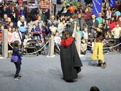 Une toute jeune combattante sortie de la foule défie un chevalier sous l'oeil expectatif de la foule.