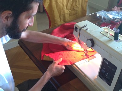 Couture des tissus pour avoir un Tabar Briselame réversible : un coté rouge, un coté jaune