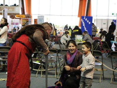 Cet enfant accompagné de sa mère voit pour la première fois une véritable épée de près.