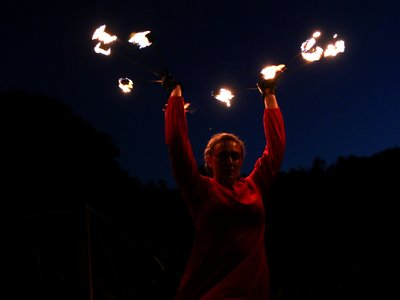 Danse aux éventails enflammés de Celmis dans le spectacle « Le Roi de Feu », mélant combat médiéval, danse, conte et feu