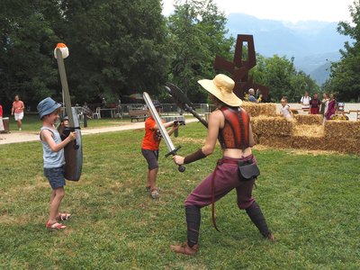 Affrontement à l'épée en mousse entre un membre de la Compagnie Briselame et des enfants