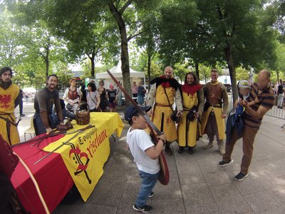 Un enfant fier de brandir l'épée devant le groupe de combattants